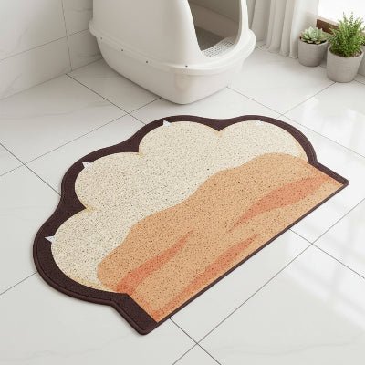 Tapis litière pour chat posé devant le bac pour récupérer les grains