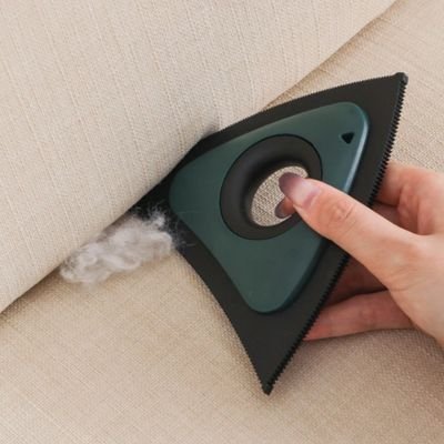 brosse anti poils nettoie sur coin du  canapé
