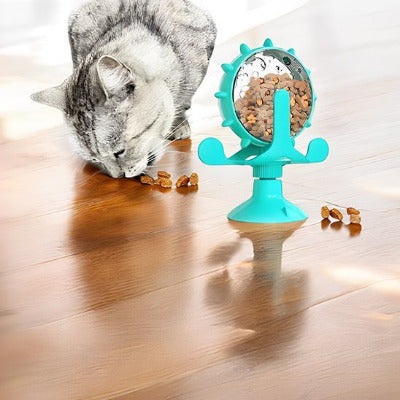 Un chat gris mange des croquettes tombées du distributeur de croquettes pour chat