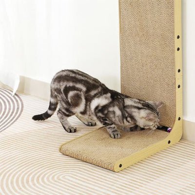 Chat jouant à la balle caché dans le griffoir pour chat