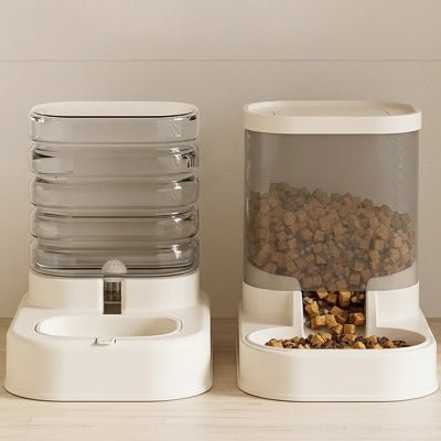 distributeur de croquettes et de l'eau posé sur le sol