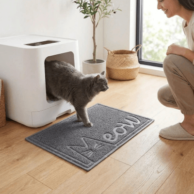 une femme observe son chat sortir sur le tapis litiere chat