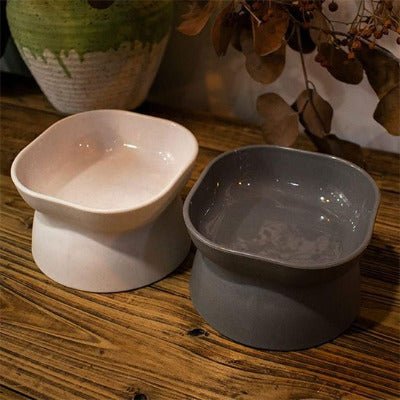 gamelle chat surélevée grise et blanche posée sur une table