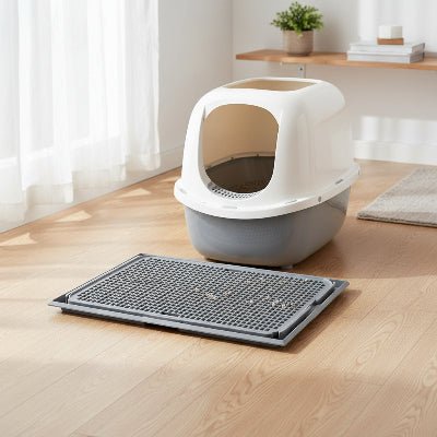 tapis litière pour chat gris placé devant un bac 